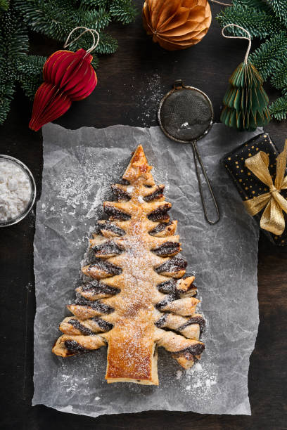 istock Puff pastry Christmas tree with chocolate paste, sprinkled with powdered sugar on old dark wooden background. Christmas or Xmas pastries. Top view. Copy Space 1373159174
