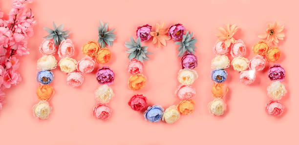 istock Abstract flower composition, spring background. Words mom from flowers on pink background, minimal holiday concept. Women's day or mother's day card, happy birthday 1373159179