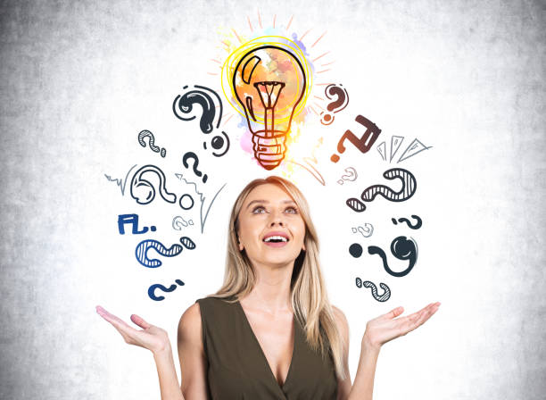istock Businesswoman with hands up smiling, question marks and light bulb 1373165130