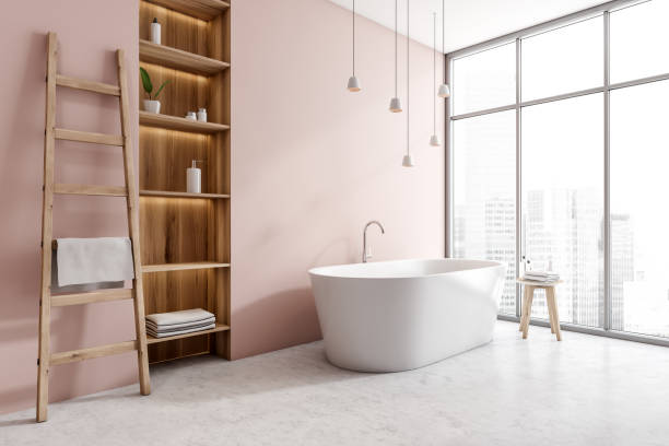 istock Light bathroom interior with bathtub, shelf rack and window with city view 1373165361