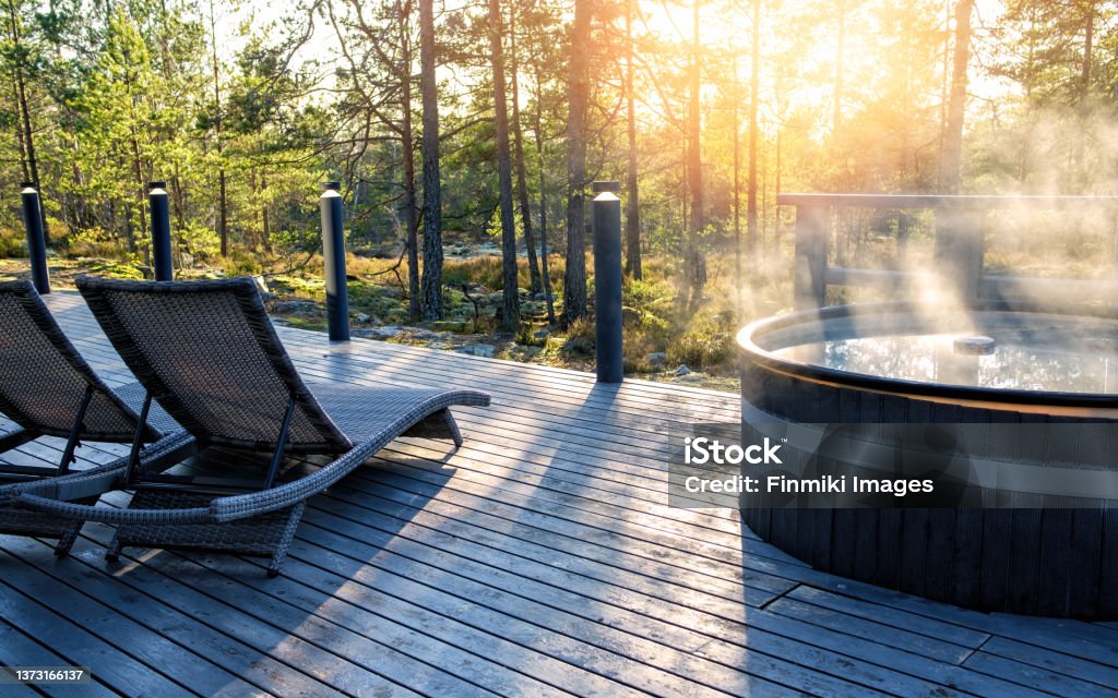 Modern big barrel outdoor hot tub in the middle of forest Modern big barrel outdoor hot tub in the middle of forest. The hot tub's soothing warm water relaxes muscles and eases tensions, so your worries can simply melt away. Hot Tub Stock Photo