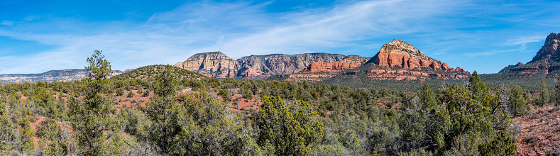 Greater Sedona and the Verde Valley are areas of uncommon beauty and diversity in the desert of Northern Arizona. It is known for its wide-open vistas, red-rock buttes, steep wooded canyons, pine forests and riparian corridors. Nearby Oak Creek, West Fork and the Verde River provide cool green shade in the spring and summer and a kaleidoscope of color in the fall. Much of this region is within the Coconino National Forest which includes several designated national wilderness areas. This scene of Grassy Knoll, Lost Wilson Mountain and Soldier Heights with contrasting green trees was photographed from the Mescal Trail in Coconino National Forest near Sedona, Arizona, USA.
