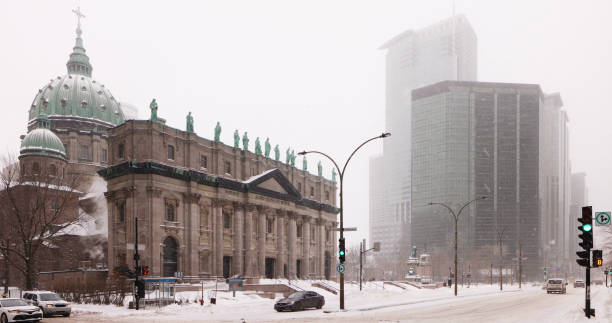 Downtown Montreal Winter street scene under snow fall with Marie-Reine-du-monde cathedral Downtown Montreal Winter street scene under snow fall with Marie-Reine-du-monde cathedral. mary queen of the world cathedral stock pictures, royalty-free photos & images