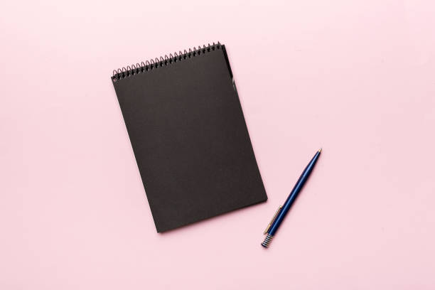 istock school notebook on a colored background, spiral black notepad on a table Top view 1373171101