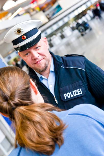 Airport police officer of the German police  checks a female passenger stock photo