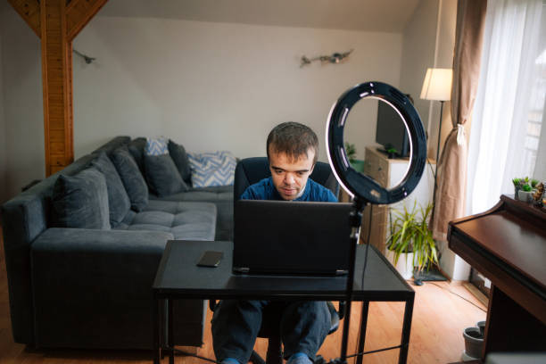 istock Young man with dwarfism vlogging from home 1373174803