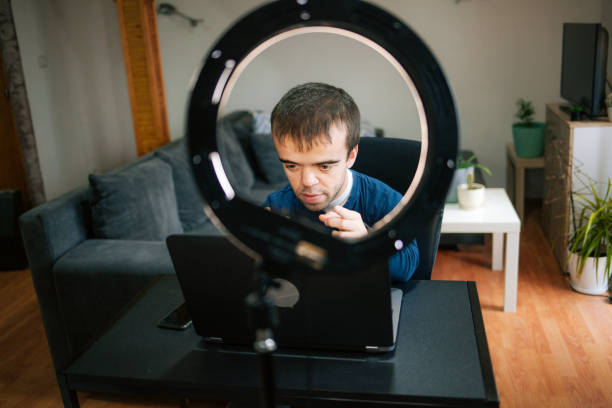 istock Young man with dwarfism vlogging from home 1373174940