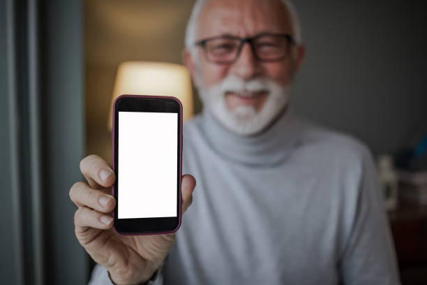 Portrait of a senior man holding a smart phone. Chroma key.