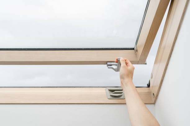 istock Woman open energy efficient attic window in wooden frame 1373176844