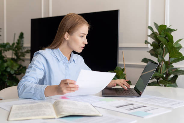 Busy woman using laptop and documents when working home