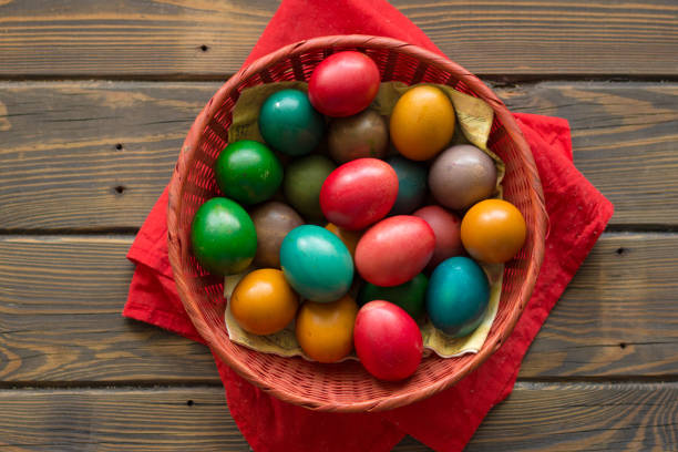 istock Top view of a Kozunak (Traditional Easter homemade sweet bulgarian bread) and colored eggs in a red wicker basket 1373177164