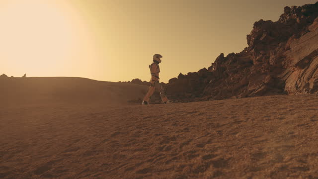 A walk on Mars. Female astronaut exploring rust colored desert. Touching stone walls