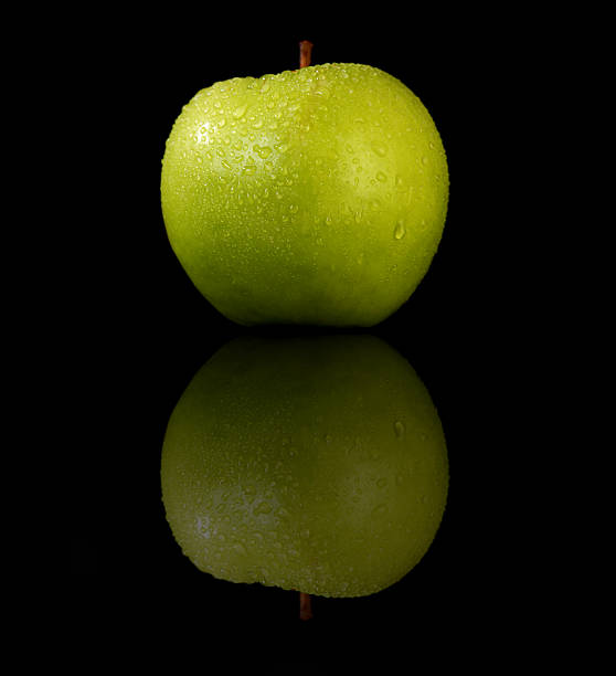organic green apple on reflective black background