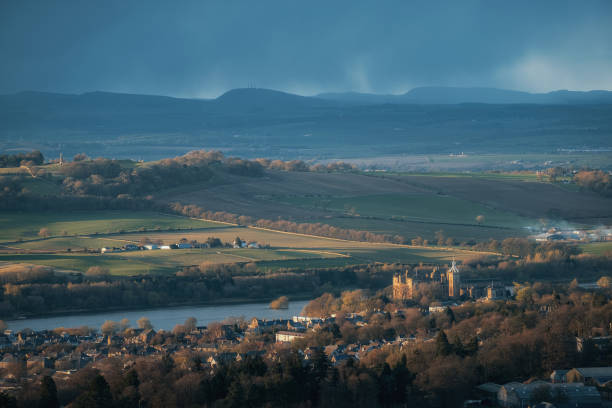Top view of a Scottish town with an old castle on the lake at sunset stock photo