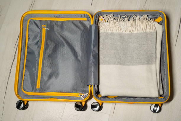 istock Packing suitcase. Yellow plastic travel bag. Clothes for a trip 1373183691