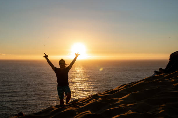 istock Young latin man at the beach with sunset at the background 1373184614