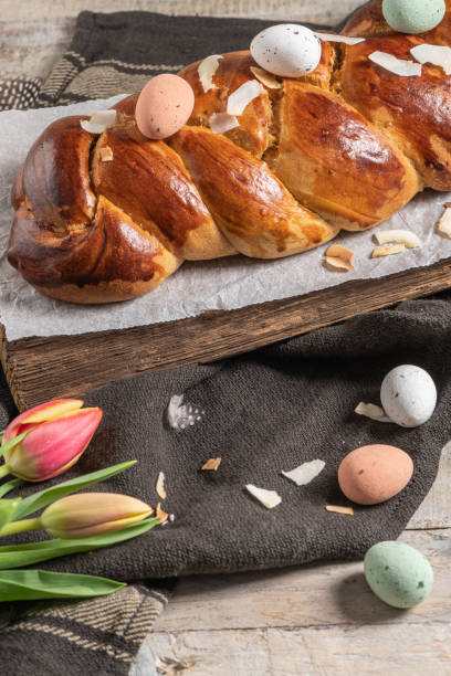 istock Portuguese traditional Easter cake. Folar with eggs on easter table. Blossom tulips, colorful painted eggs and feathers 1373184656