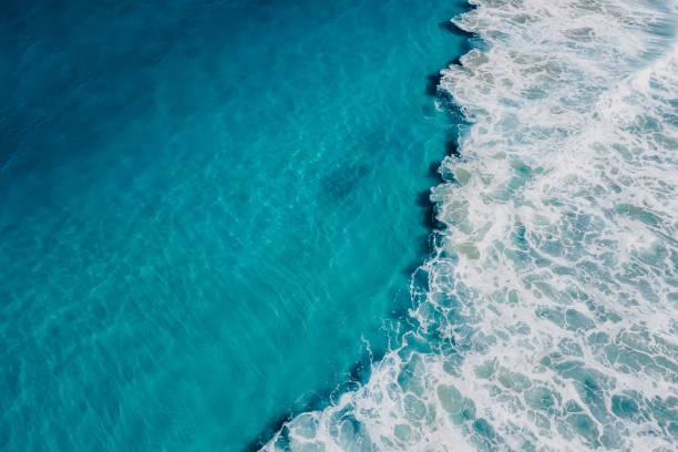 Top view of blue ocean water and wave, aerial view Top view of blue ocean water and wave, aerial view spume stock pictures, royalty-free photos & images