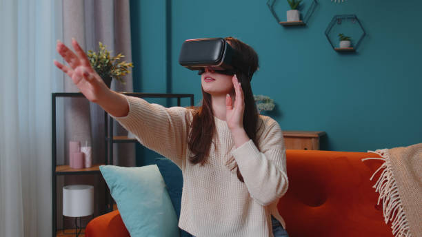 istock Young girl use virtual reality headset glasses at home play 3D video game making gestures with hands 1373188662
