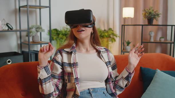 istock Young girl use virtual reality headset glasses at home play 3D video game making gestures with hands 1373189559