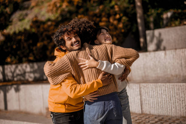 istock Young people feeling joyful and hugging in the street 1373190754