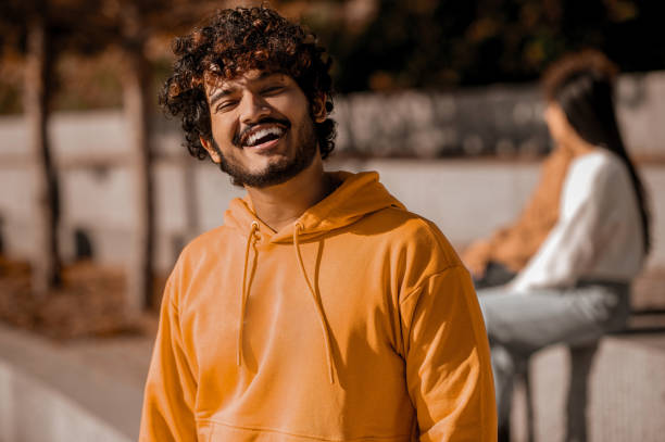 istock Young guy in orange hoodie looking happy 1373190764
