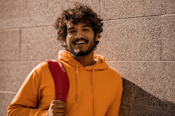 istock Curly-haired young man with a backpack in the street 1373190786
