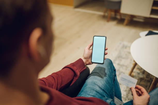 istock Man hands with smartphone and credit card while online shopping at home 1373190949