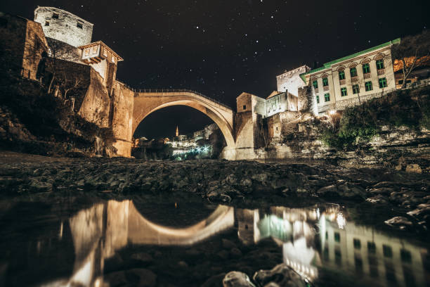 Old Bridge on river Neretva in Bosnia and Herzegovina Old Bridge and ancient buildings on Neretva river in Mostar in Bosnia and Herzegovina in the night. Famous tourist destinations in Europe. Neretva river and old mosques. mostar stock pictures, royalty-free photos & images