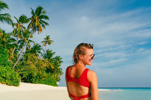 Rear view of young woman at tropical beach