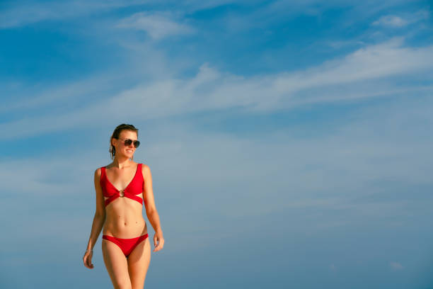 istock Beautiful woman walking at tropical beach 1373217632