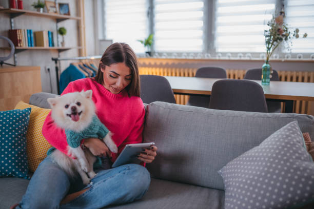 istock A young woman uses a tablet and relaxes with her dog 1373219298