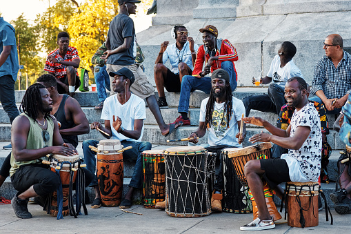 June, 2018 - Montreal, Canada: African American males playing drums and djembe bongo in mount royal park in Montreal, Canada.