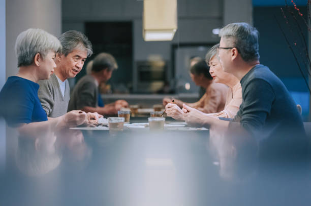 azjatyccy chińscy starsi przyjaciele cieszący się kolacją w domu spotkanie towarzyskie - dining senior adult friendship mature adult zdjęcia i obrazy z banku zdjęć