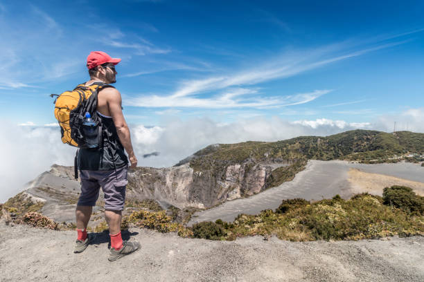 hiker with backpack contemplating the landscape in the Irazu Volcano National Park in Costa Rica hiker with backpack contemplating the landscape in the Irazu Volcano National Park in Costa Rica irazu stock pictures, royalty-free photos & images