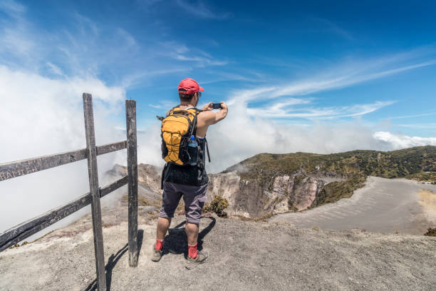 hiker with backpack taking a selfie of the landscape in Irazu Volcano National Park in Costa Rica hiker with backpack taking a selfie of the landscape in Irazu Volcano National Park in Costa Rica irazu stock pictures, royalty-free photos & images