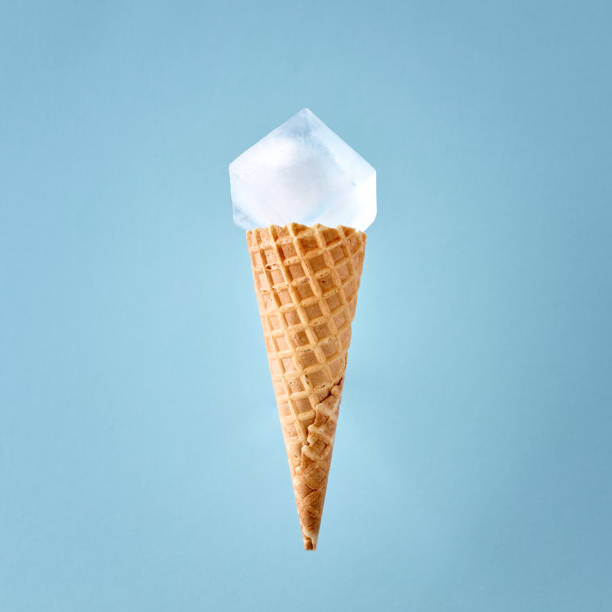 istock Ice cream waffle cone with a big ice cube on blue background. Minimal cold summer food concept. 1373231076