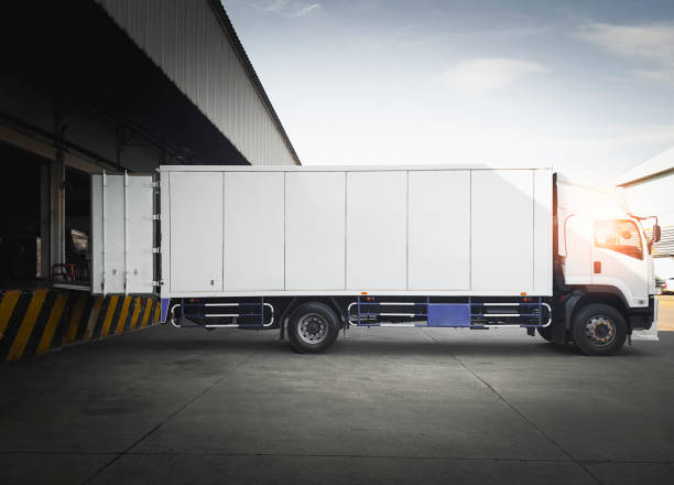 istock Cargo Container Trucks Parked Loading at Dock Warehouse. Shipping Cargo Trucks. Distribution Warehouse Center. Lorry. Industry Freight Trucks Transport Logistics. 1373234819