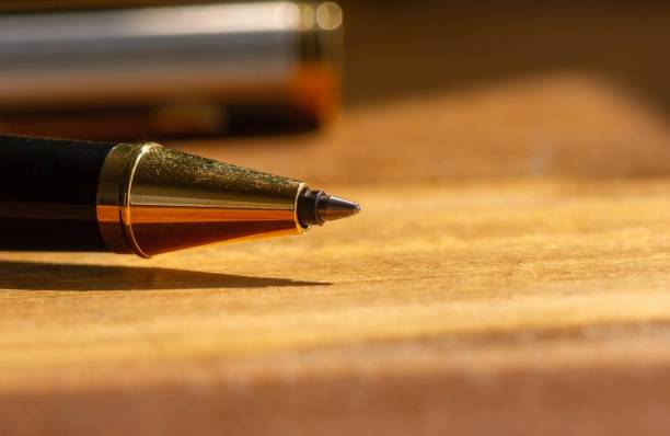 istock A gold pen on wooden table 1373235654