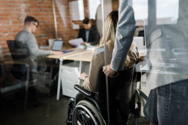 istock Assisting disabled colleague in the office! 1373236351