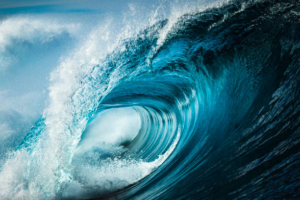 detalle de cerca de la poderosa ola azul azulado rompiendo en el océano abierto en una tarde soleada y brillante - surf fotografías e imágenes de stock