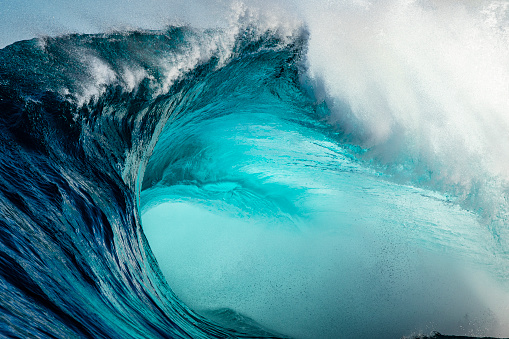 Extreme close up detail of powerful teal blue wave breaking wildly on a reef bombora off the coast of southern Australia.
