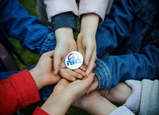 Group of kids holding a peace rosette in hands, High angle view stock photo