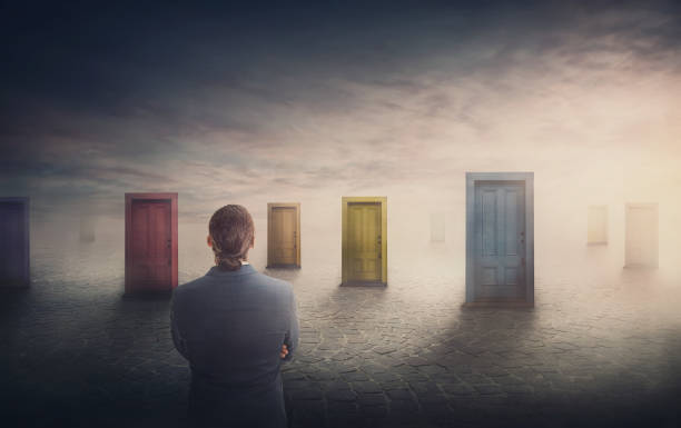 istock Doubtful businessman in front of multiple doors of diverse colors as symbol for different opportunities. Business challenge, choosing a correct doorway. Difficult decision concept, failure or success 1373244331
