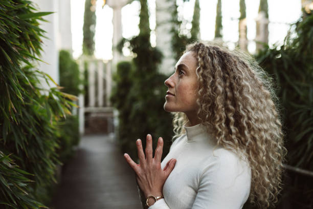 close-up pretty curly-haired woman, doing yoga, thinking about relaxing
