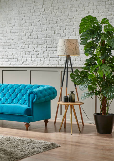 istock Blue quilted sofa in the room, white brick and brown classic grid wall background, plant, middle table, lamp home decoration interior style. 1373248192
