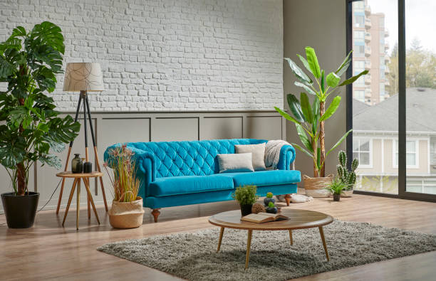 istock Blue quilted sofa in the room, white brick and brown classic grid wall background, plant, middle table, lamp home decoration interior style. 1373248194