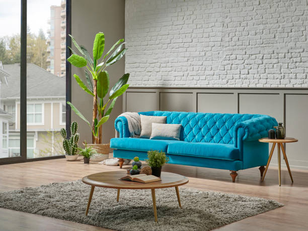 istock Blue quilted sofa in the room, white brick and brown classic grid wall background, plant, middle table, lamp home decoration interior style. 1373248205