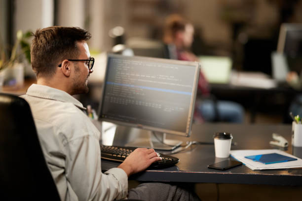 istock Happy male programmer working on desktop PC in the office. 1373248284