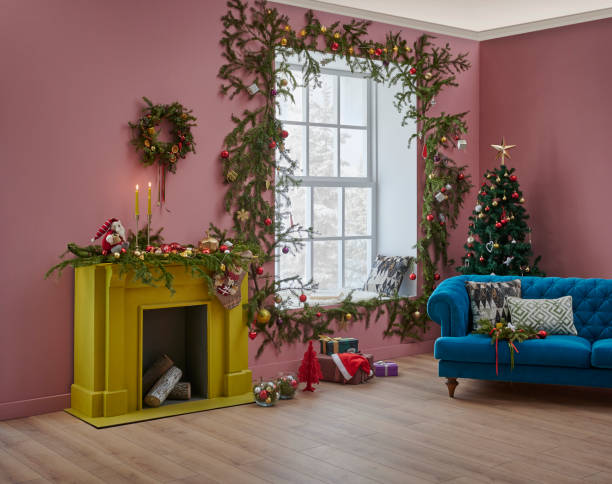 istock Christmas tree and yellow fireplace in front of the decorative windows, interior room, pine branch decoration, gift box and furniture chair and sofa design. 1373249545